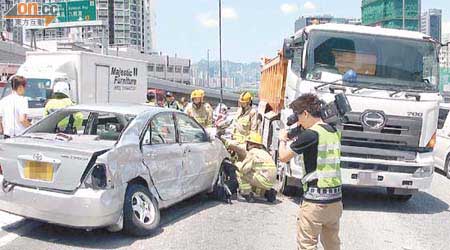 私家車與泥頭車相撞，消防員到場救援。	（左錦鴻攝）