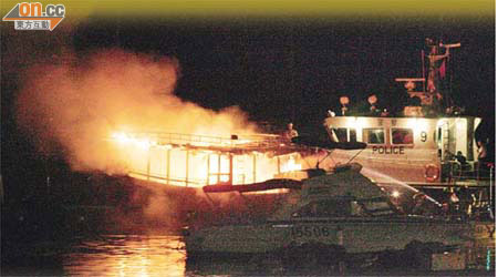 中式遊艇遭縱火，火光熊熊，消防員正開喉射水。	（王偉安攝）
