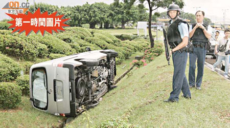 海關運載毒品證物的客貨車在機場南路翻車，警方荷槍實彈戒備。	（林明強攝）