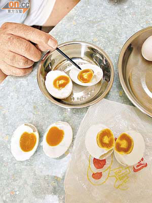 陳先生指示鹹蛋的蛋黃內有白色半透明異物。	（陳展鴻攝）