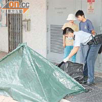 葵興邨跳樓<br>消防員在葵興邨將墮樓婦人屍體抬下。	（左錦鴻攝）