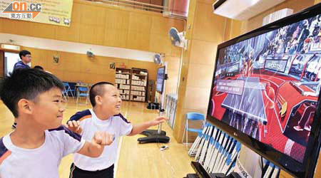 學生在「虛擬體育課」中模仿畫面中的影像，學習各種體育活動技巧。	（羅錦鴻攝）