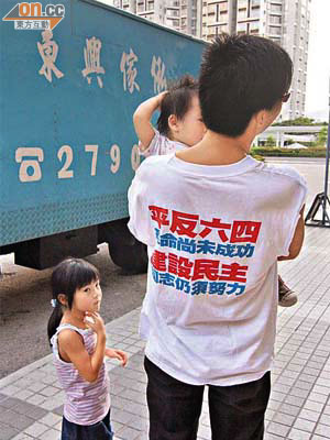住在藍田麗港城的黃先生因穿着「平反六四」衣服及手持抗議標語，被警方扣查。	（胡耀威攝）