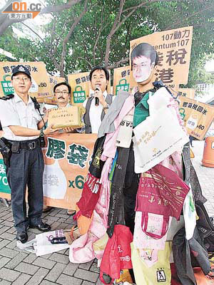 動力成員戴上邱騰華面具，身穿掛滿環保袋的衣服，諷刺邱騰華強推膠袋徵費。	（羅錦鴻攝）