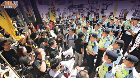 警方阻止人民力量示威者前進，立法會議員黃毓民（圖中黑衣者）上前與警員對質。	（高嘉業攝）