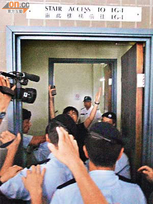 港大學生（高舉雙手者）李成康欲到陸佑堂向李克強示威，但遭警員強行拖到後樓梯禁錮。