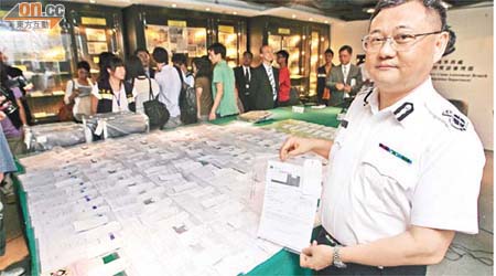 梁國雄展示行動期間檢獲的數十張偽造文件，包括虛假稅單、電費單及水費單。