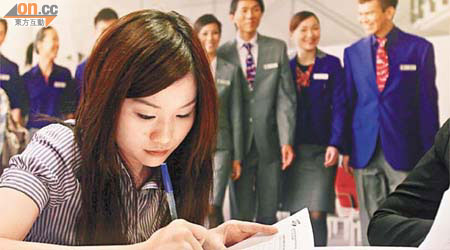 有意投身航空服務業的年輕人在博覽會即時填寫申請表。	（翁志偉攝）