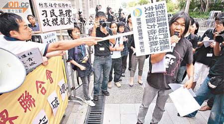 有聲言「反暴力」的示威者，用示威牌三次拍打社民連議員梁國雄的頭部。	（麥潤田攝）