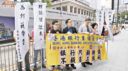 銀行業僱員協會約十名代表昨到滙豐銀行總行示威，抗議該行裁員計劃。	（高嘉業攝）