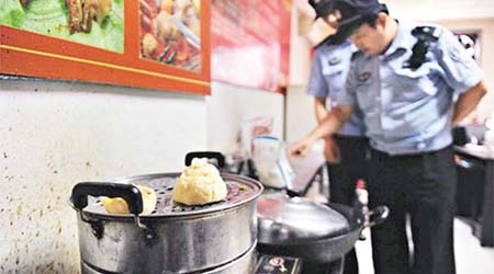 北京執法人員到食品培訓學校調查，檢視教室內的廚具。	（互聯網）