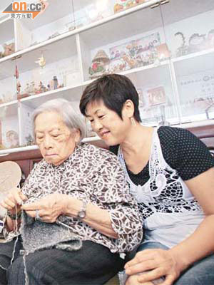 八十七歲周婆婆（左）最愛編織，有助減慢腦部衰退。家居儲物櫃換成透明玻璃門，方便她尋找物件。旁為其媳婦。	（伍鎮業攝）