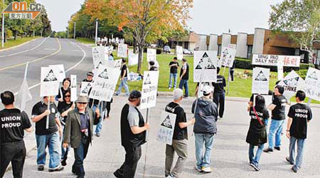 多倫多《明報》員工手持標語牌罷工遊行。	（本報多倫多傳真）