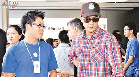 吳彥祖（右）對iPad2好有興趣，篤住螢幕問職員有乜功能。	（盧志燊攝）