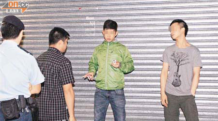 警員盤查兩名青年時，其中一人不停吸煙，態度囂張。	（蕭植梧攝）