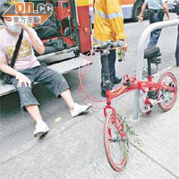 險被塌樹壓死的男子受輕傷坐在路旁，其單車亦移至身旁。