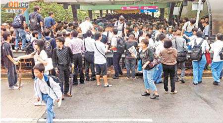 千人逼爆<br>大批趕上班上學的市民擠在行人通道上，有人索性攀欄離開。	（讀者提供）