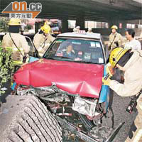 的士撞石壆損毀，老司機受傷呆坐車內待救。	（楊偉嶽攝）