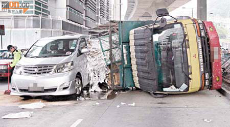 貨車掃欄後翻側，險壓毀鄰線七人車。	（梁卓明攝）