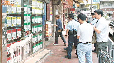 探員在被淋油店舖調查，東主（右二）到場協助。（林少兒攝）