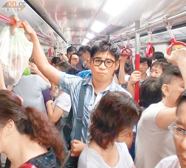 易容記者（戴眼鏡）與其他港鐵乘客擠在車廂內，期間未被察覺容貌有異。