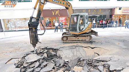 爆水管路面下陷，工人正在進行搶修。（林少兒攝）