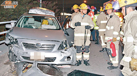 肇事私家車撞欄及翻觔斗後，全車嚴重損毀。（梁國雄攝）