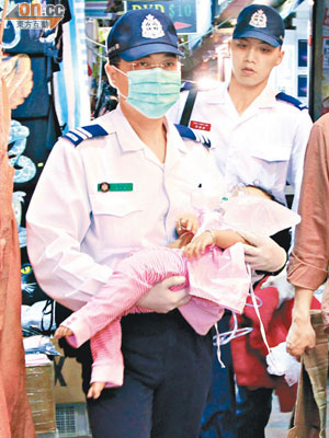 跌落床受傷的尼籍女嬰由救護員送院。（馮戈攝）