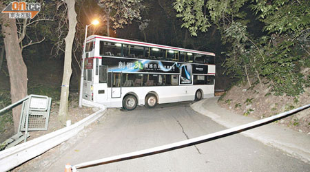 巴士被「卡」在狹窄彎位，警方封鎖現場調查。（林振華攝）