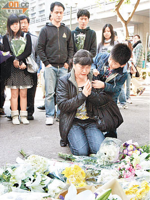 痛失愛女的廖海燕母親，昨在火場附近跪地哭拜亡女。（冼耀華攝）