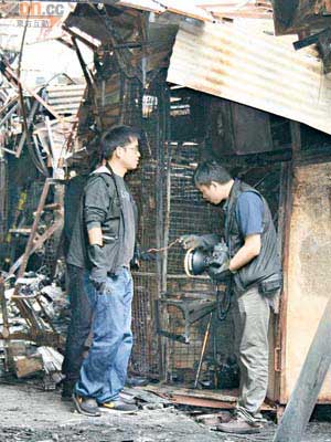重案組探員在焚毀的排檔內檢驗電線。（譚珮蓮攝）
