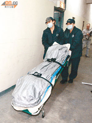 仵工將吞槍自殺的台灣商人遺體舁送殮房。（陳展鴻攝）