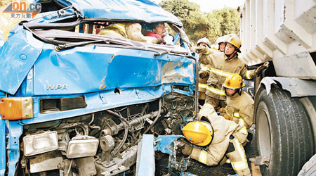 吊臂貨車撞向泥頭車車頭凹陷，消防員拯救被困乘客。（湯志源攝）