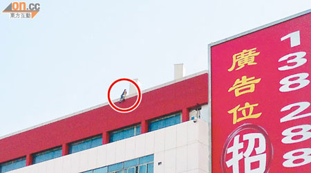一名女子在交通樓天台危坐（紅圈示）。