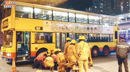 消防員拯救捲入巴士車底的車長。（呂浩鋒攝）