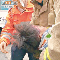 兩歲男童由消防員抱上救護車送院。