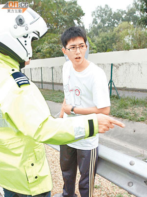 險死踩單車青年向警員講述經過。（許錦雄攝）