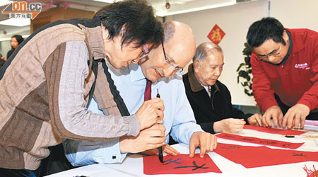韋達誠（左二）學寫揮春雞手鴨腳。（港鐵提供）