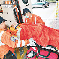 墮地受傷工人由救護員送院救治。（黃智康攝）