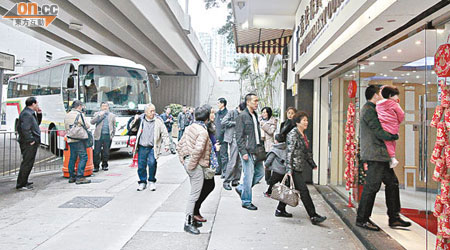 大批內地團旅客乘旅遊巴到紅磡區珠寶店的購物點。