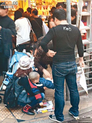 討論區照片流傳，懷疑有內地母親手抱嬰兒在旺角街上大便，地上墊上報紙。