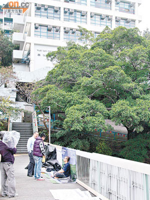 香港華仁書院前副校長在行人天橋上絕食抗議，教職員向他了解情況。（陳展鴻攝）