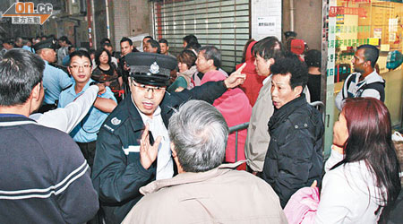 昨晚中銀分行外人龍再現，警員指示市民排隊方向。