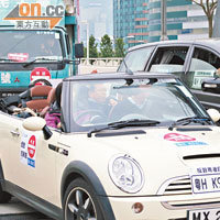 遊行的車隊貼上「粵HK9413」的字句，諷刺自駕遊計劃會令本港交通「九死一生」。（李惠攝）