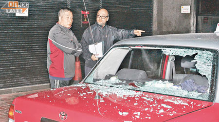 的士車窗被砸毀，司機（左）協助調查。（楊偉嶽攝）