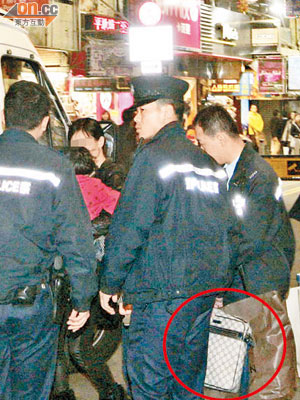 警員手持起回的手袋（圓圈示），及將涉案女子帶署調查。（王譯揚攝）