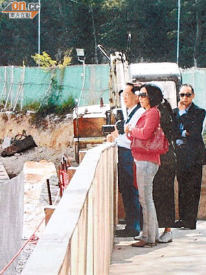 手持相機的曾蔭權在劉鑾鴻（右）陪同下參觀興建中的御海南灣樓盤。