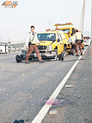 被撞巡邏車事後被拖離現場，路面遺下大攤血漬。左為肇事七人車。（曾志恒攝）