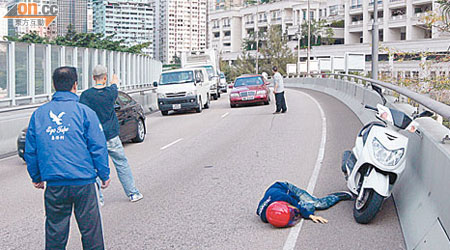 鐵騎士暈倒路旁，三名熱心市民在場指揮交通。（曾志恒攝）