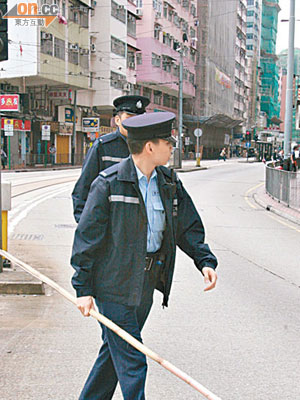 警員在筲箕灣檢走墮下傷人的晾衫竹。（馬景峯攝）